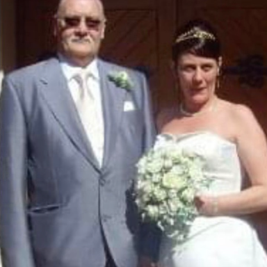 A bride in a white gown holding a bouquet, standing next to a man in formal attire.