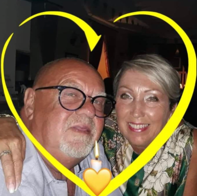 A smiling couple embracing with a yellow heart outline around them.