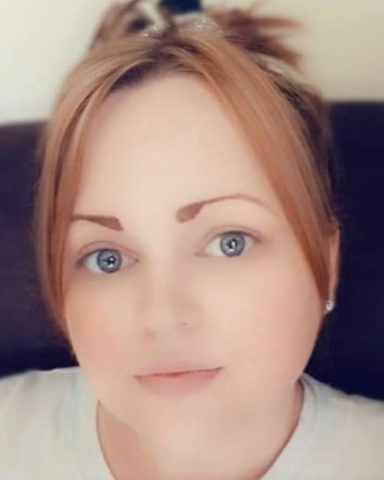 Close-up of a person with light brown hair and blue eyes, looking directly at the viewer.