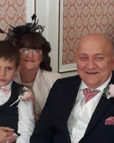 A woman, a man, and a boy, all dressed elegantly, smiling at the camera.