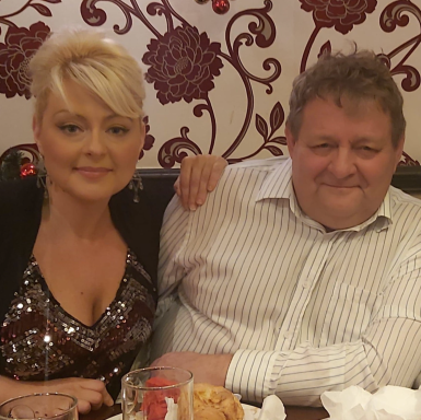 A woman with blonde hair and a man with curly hair sitting together in a restaurant.